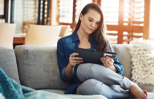 Home, tablet and card of woman, reading and smile for info of credit score.